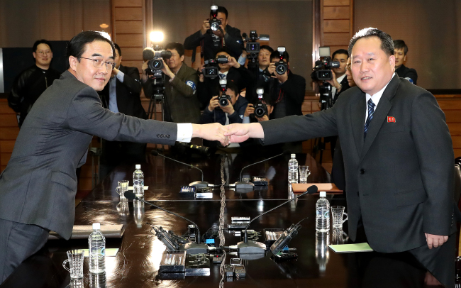 South Korean Unification Minister Cho Myoung-gyon (left) and North`s Ri Son-gwon shake hands after agreeing to inter-Korean summit on March 29. Yonhap
