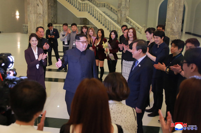 North Korean leader Kim Jong-un speaks to members of K-pop group Red Velvet at the East Pyongyang Grand Theater in Pyongyang on Sunday. (Yonhap-Joint Press Corps)