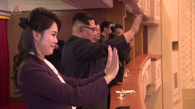 North Korean leader Kim Jong-un (right) and his wife Ri Sol-ju wave at the S. Korean pop singers after their performances at East Pyongyang Grand Theater in Pyongyang on Sunday. (Yonhap-Joint Press Corps)