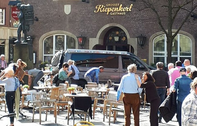 People stay in front of a restaurant in Muenster, Germany, Saturday, April 7 after a vehicle crashed into a crowd killing four people and injuring 20 others. The German news agency dpa has quoted police as saying the driver of that car in Muenster has killed himself. (AP)