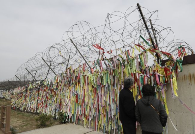 Visitors look at the ribbons carrying messages wishing the reunification and peace of the two Koreas at the Imjingak Pavilion in Paju, South Korea, Saturday, April 7. (AP)
