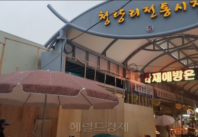 화재가 난 전통시장의 복구도 부진하다. 지난 1월 화재가 발생한 청량리 전통시장 상가(사진 왼쪽, 나무가림막)는 구획소유주의 동의를 받지 못해 재건사업이 진행되고 있지 못하다. [사진=김성우 기자/zzz@heraldcorp.com]