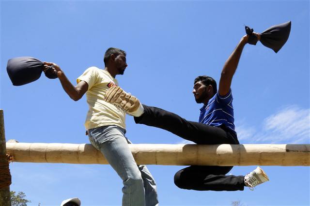 <YONHAP PHOTO-2703> epa06655357 Two Sri Lankan take part in the 'kotta pora,' or pillow fighting contest, during the Sinhala and Tamil New Year celebrations at the Sports Ministry grounds in Colombo, Sri Lanka, 08 April 2018. Sri Lankans, both Sinhalese and Tamils, celebrate the New Year, Aluth Avurudda in Sinhala and 'Siththirai' in Tamil, falling in mid-April, mainly as a post-harvest celebration. While the main events are celebrated on 13 and 14 April, considered as auspicious times in local astrology, further celebrations are held by the Ministry of Megapolis and Western Development with sports, culture and traditional activities events. EPA/M.A.PUSHPA KUMARA/2018-04-09 06:22:12/ <저작권자 ⓒ 1980-2018 ㈜연합뉴스. 무단 전재 재배포 금지.>
