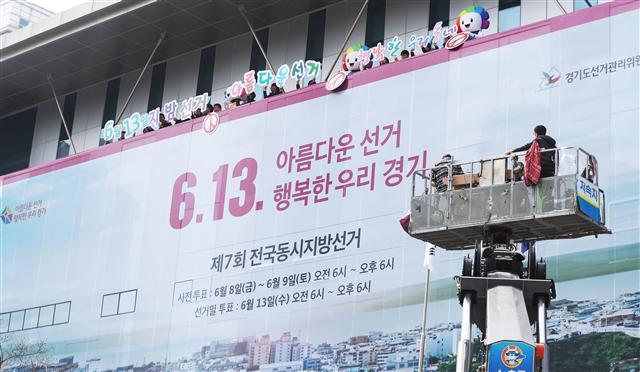 <YONHAP PHOTO-3844> '아름다운 선거, 행복한 우리 동네' (수원=연합뉴스) 홍기원 기자 = 제7회 전국동시지방선거를 65일 앞둔 9일 오전 경기도 수원시 경기도선거관리위원회에서 관계자들이 청사 벽면에 지방선거를 알리는 래핑 작업을 하고 있다. 2018.4.9 xanadu@yna.co.kr/2018-04-09 10:22:20/ <저작권자 ⓒ 1980-2018 ㈜연합뉴스. 무단 전재 재배포 금지.>