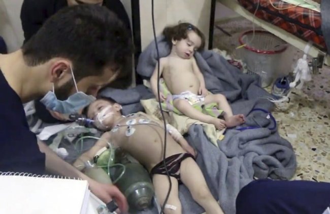 This image made from video released by the Syrian Civil Defense White Helmets shows medical workers treating toddlers following an alleged poison gas attack in the opposition-held town of Douma, in eastern Ghouta, near Damascus, Syria, Sunday, April. 8. (AP)