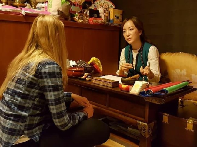 Korean mudang Pang Eun-mi offers consultation to her client at her house in Ilsan. (Photo courtesy of Pang Eun-mi)