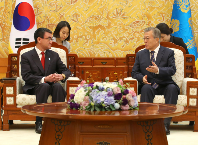 President Moon Jae-in (right) speaks with Japanese Foreign Minister Taro Kono in Seoul on Wednesday. Yonhap