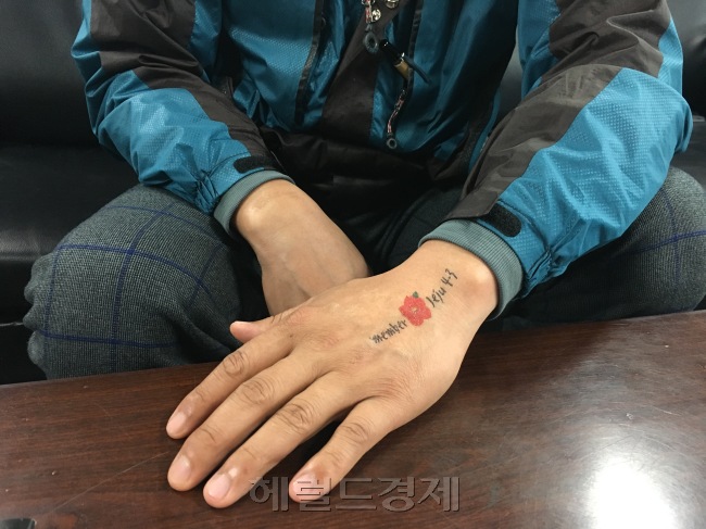[8일 세월호 희생자 故영석 군 父 오병환(48) 씨가 손에 붙인 ‘리멤버 제주 4ㆍ3’ 판박이. 오 씨는 세월호 이후 다른 사람들의 고통에 더 눈뜨게 되었다고 이야기했다. 사진= 김유진 기자/kacew@heraldcorp.com]
