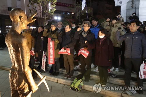 Members of a civic group rally in front of a model statue, which symbolizes Korean victims of forced labor under Japan's colonial rule, in South Korea's largest port city of Busan on Jan. 24, 2018. They vowed to erect such a statue in front of the Japanese Consulate in the city on May 1. (Yonhap)