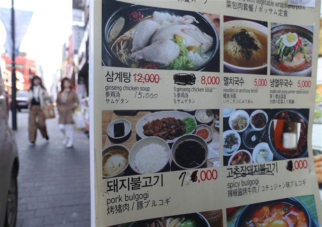 외식물가 등 서민 생활 물가가 눈에 띄게 오르고 있는 가운데 서울 명동의 한 음식점 메뉴 안내판에 인상된 가격이 손글씨로 쓰여 있다. 급격한 물가 인상을 실감케 한다.  [연합뉴스]