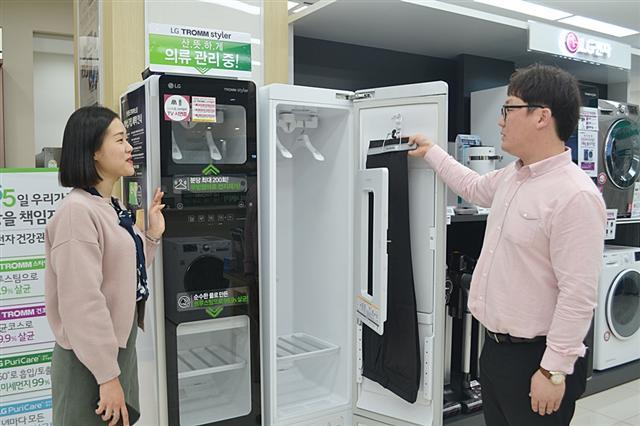 전자랜드프라이스킹 직원이 매장을 찾은 한 고객에게 의류관리기를 설명하고 있다.