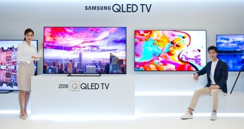 Models pose with Samsung Electronics Co.'s QLED TVs in this photo released by the company on April 17. (Yonhap)