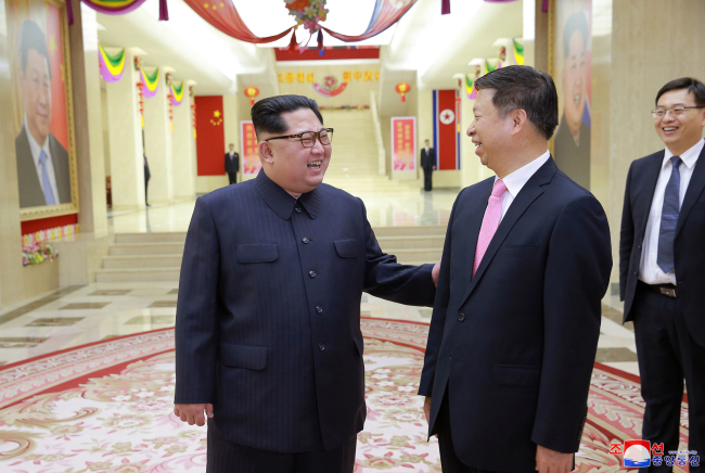 This photo, carried by North Korea's Rodong Sinmun on April 15, 2018, shows North Korean leader Kim Jong-un (left) greeting Song Tao, a visiting senior Chinese official, in Pyongyang. (For Use Only in the Republic of Korea. No Redistribution) (Yonhap)