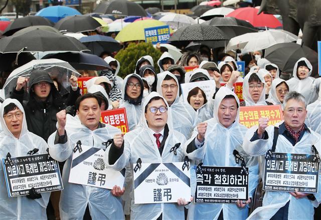 ‘문재인 케어’ 도입에 반대하는 의사협회가 지난 8일 오후 서울 동화면세점 앞에서 대한의사협회 관계자들이 이대목동병원 의료진 구속 규탄 집회를 하고 구호를 외치고 있다.  [연합뉴스]