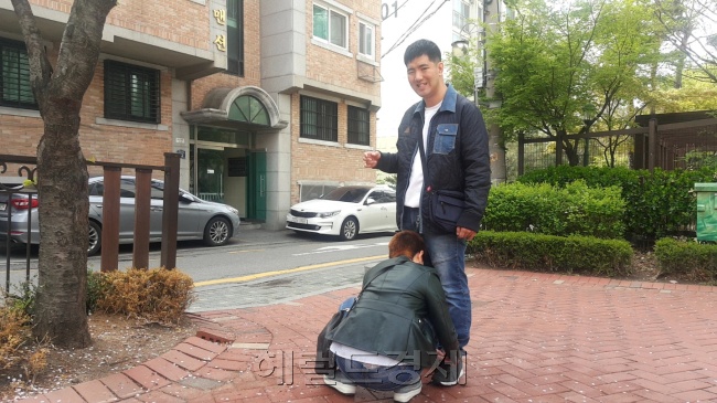 외출 전 발달장애인 현우 씨의 운동화 끈을 묶어주고 있는 어머니 김경미 씨.  그는 발달장애인이 지역사회에서 어울릴 수 있는 기반이 하루빨리 마련됐으면 좋겠다고 말한다.