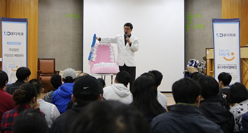 <고광욱 파주 유디치과의원 대표원장이 치아모형을 이용해 장애인들에게 올바른 칫솔질 교육을 하고 있다>