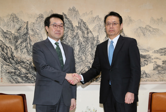 South Korea's top nuclear envoy Lee Do-hoon (left) meets with his Japanese counterpart Kenji Kanasugi in Seoul on Monday. (Yonhap)