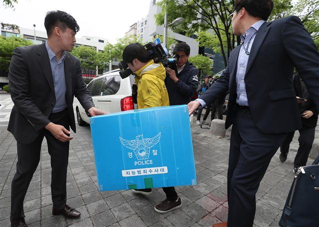 네이버 댓글 여론조작 사건을 수사하는 경찰 수사관들이 24일 느릅나무 출판사 세무 업무를 담당한 서울 강남구 한 회계법인에서 압수수색을 마친 뒤 압수물품을 들고 나오고 있다.  [연합뉴스]