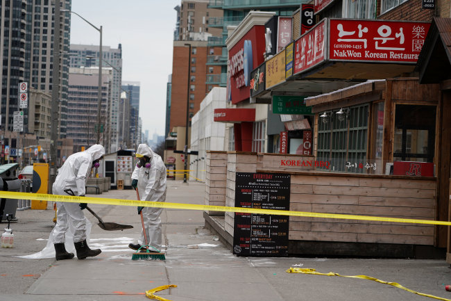 Workers clean up blood stains in Yonge and Finch area in Toronto, Canada, known as one of the Koreatowns there, following a van that attacked multiple people. (Yonhap)