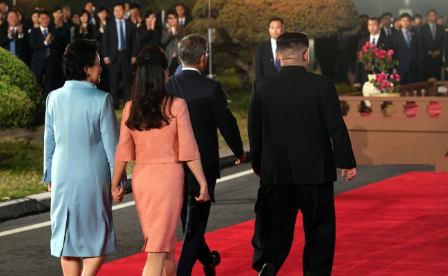 South Korean first lady Kim Jung-sook (far left) and her North Korean counterpart Ri Sol-ju hold hands as they attend Friday's inter-Korean summit. (Yonhap)