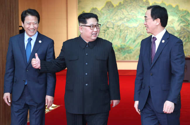 North Korean leader Kim Jong-un (center) talks with South Korean Unification Minister Cho Myoung-gyon (right) as he comes out of talks with his South Korean counterpart Moon Jae-in at the Peace House of the truce village of Panmunjom on April 27, 2018. Moon's chief of staff, Im Jong-seok, is on the left. (Yonhap)