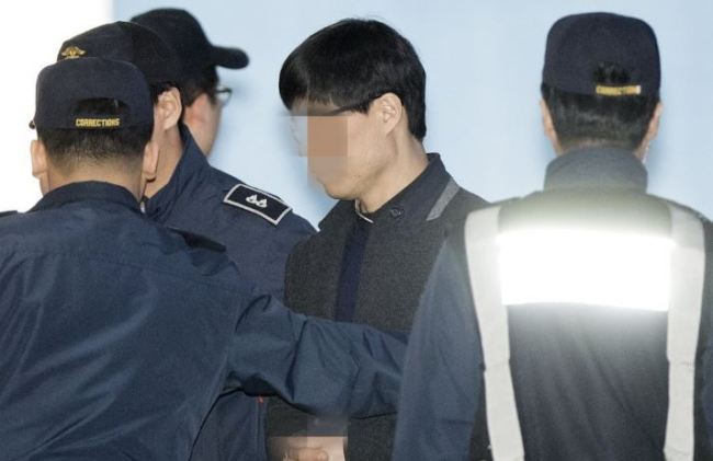 The surgeon who did not provide proper care to late singer Shin Hae-chul after an abdominal surgery in 2014 is arrested in this file photo. (Yonhap)