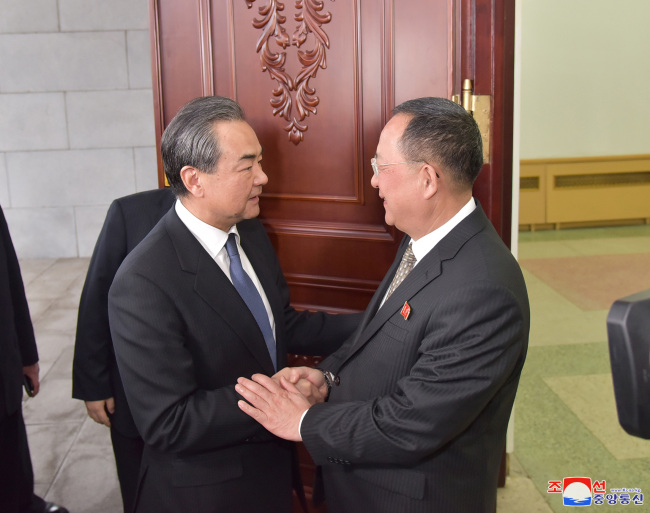Chinese Foreign Minister Wang Yi (left) and North Korean Foreign Minister Ri Yong-ho meets in Pyongyang on Wednesday to hold talks over the two countries' ties and the situation on the Korean Peninsula, in this photo carried by the Korean Central News Agency on Thursday. (For Use Only in the Republic of Korea. No Redistribution) (Yonhap)