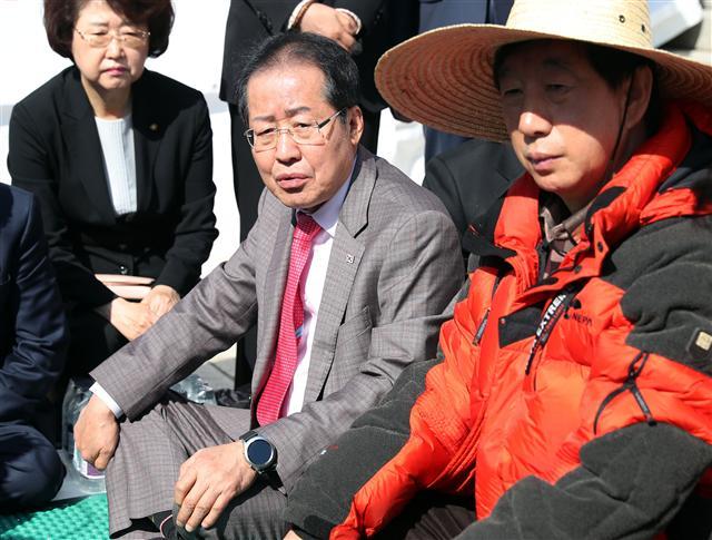 자유한국당 홍준표 대표가 4일 오전 ‘드루킹’ 특검을 요구하며 국회 본청 앞에서 단식농성 중인 김성태 원내대표를 찾아와 얘기하고 있다. 김 원내대표는 전날 더불어민주당원의 댓글조작 사건(드루킹 사건)과 관련해 정부·여당의 특검 수용을 촉구하며 단식에 들어갔다.  [연합뉴스]