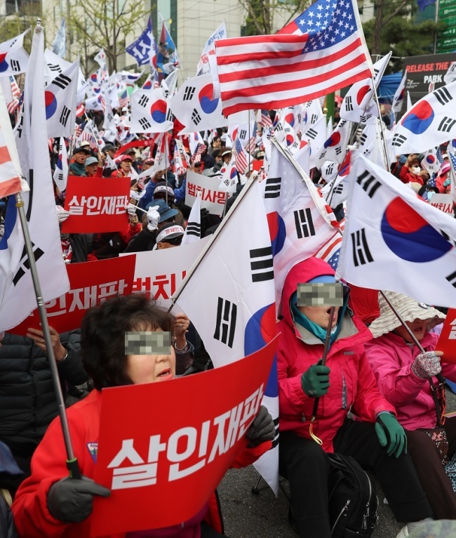 박근혜 전 대통령 1심 선고일인 6일 오후 서초구 서울중앙지법 앞에 박 전 대통령 지지자들이 태극기와 성조기 그리고 피켓을 들고 시위를 벌이고 있다. [사진=연합뉴스]