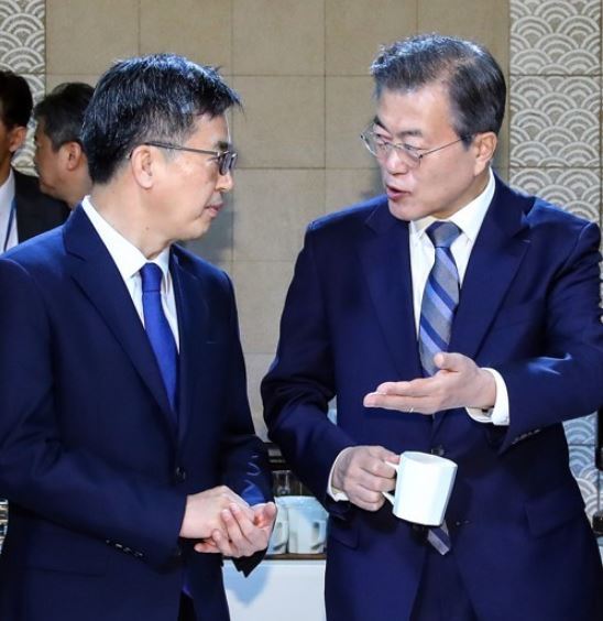 President Moon Jae-in (right) talks with Finance Minister Kim Dong-yeon before a Cabinet meeting on April 24, 2018. (Yonhap)