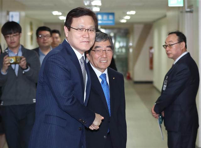 윤석헌 신임 금융감독원장(오른쪽)이 9일 오전 서울 종로구 정부서울청사 금융위원회를 방문, 최종구 금융위원장과 악수하고 있다. [연합뉴스]