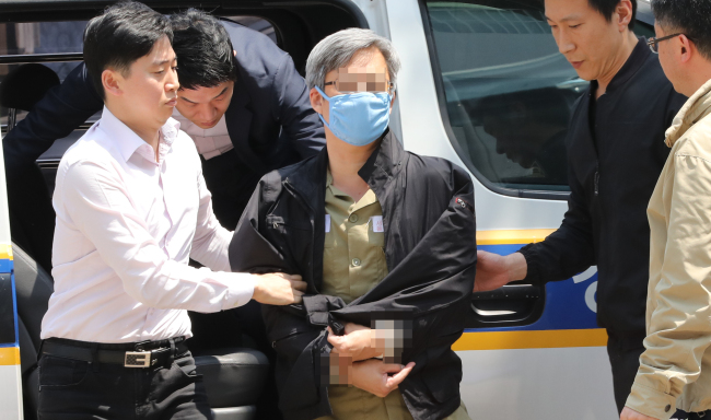 he power blogger, aka "Druking", charged over an alleged massive manipulation of online comments in news articles, is escorted by police in Seoul on May 10, to be questioned over fresh graft allegations in connection with a ruling party lawmaker. (Yonhap)