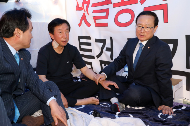 더불어민주당 홍영표 신임 원내대표(오른쪽)가 11일 오전 서울 여의도 국회 본청 앞에서 드루킹 댓글 조작 사건 특검을 요구하며 9일째 단식 농성을 이어가고 있는 자유한국당 김성태 원내대표를 찾아 대화하고 있다. 왼쪽은 더불어민주당 안민석 의원. (사진=연합뉴스)