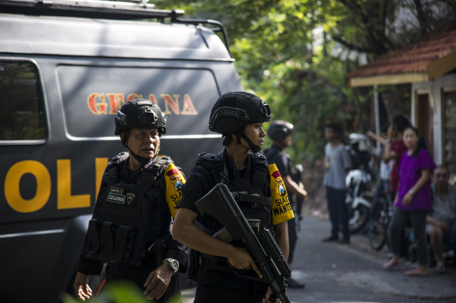 Indonesian policemen patrol outside a church following a suicide bomb in Surabaya on May 13, 2018. (AFP-Yonhap)