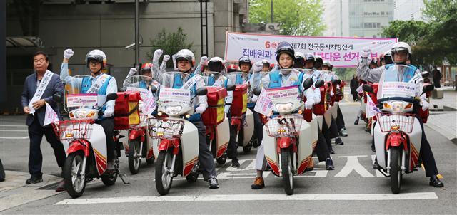<YONHAP PHOTO-4888> 집배원과 아름다운 선거 만들어봐요~! (서울=연합뉴스) 서울특별시선거관리위원회가 6·13 제7회 전국동시지방선거를 한 달 앞두고 14일 오전 서울 광화문우체국 주차장에서 개최한 '집배원과 함께하는 아름다운 선거 홍보단 발대식'에서 집배원들이 광화문 인근으로 이동하면서 파이팅을 외치고 있다. 이번 홍보활동은 다음 달 13일까지 집배원 이륜차 3천여 대에 선거일과 사전투표 등을 안내하는 스티커깃발을 부착하는 방법으로 운영된다. 2018.5.14 [서울특별시선거관리위원회 제공=연합뉴스] photo@yna.co.kr/2018-05-14 09:53:38/ <저작권자 ⓒ 1980-2018 ㈜연합뉴스. 무단 전재 재배포 금지.>