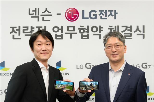 LG전자 한국모바일그룹장 이상규 부사장(오른쪽)과 넥슨 이정헌 대표가 ‘전략적 협업을 위한 업무 협약식’에서 LG G7 ThinQ 로 카이저 게임을 소개하고 있다.  [제공=LG전자]