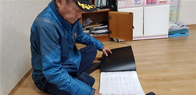 원명부를 들춰보고 있는 김진국(79) 청호동 노인회장.