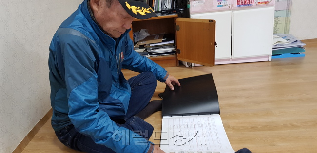 원명부를 들춰보고 있는 김진국(79) 청호동 노인회장.