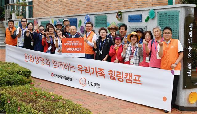 한화생명 서지훈 상무<사진 가운데>와 사랑의장기기증운동본부 박진탁 이사장, 환우가족들이  제주 라파의 집에서 기념촬영을 하고 있다.