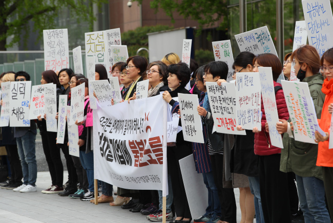 Members of the Joint Action to Eliminate Gender Discrimination in Employment protest against alleged gender discrimination in the employment process of KEB Hana Bank and KB Kookmin Bank, in front of a KEB Hana Bank building in central Seoul on April 24. (Yonhap)