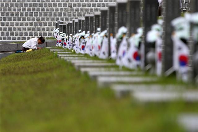 <YONHAP PHOTO-3439> 다시 '오월' (광주=연합뉴스) 정회성 기자 = 5·18 민주화운동 38주년을 하루 앞둔 17일 국립 5·18민주묘지를 찾은 유가족이 묘소를 참배하고 있다. 2018.5.17 hs@yna.co.kr/2018-05-17 09:25:34/ <저작권자 ⓒ 1980-2018 ㈜연합뉴스. 무단 전재 재배포 금지.>