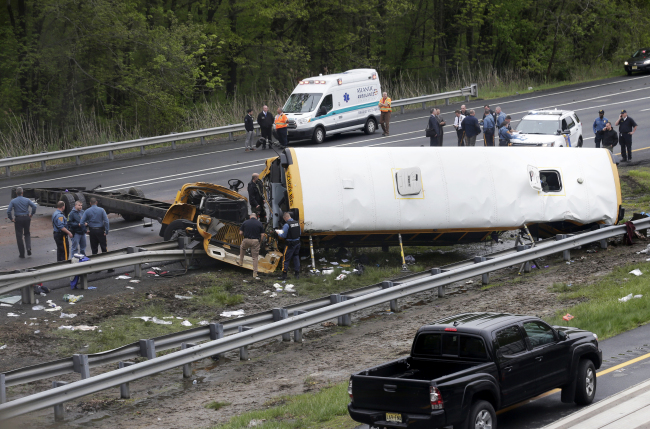 Emergency personnel work at the scene of a school bus and dump truck collision, injuring multiple people, on Interstate 80 in Mount Olive, New Jersey, on May 17, 2018. (AP-Yonhap)