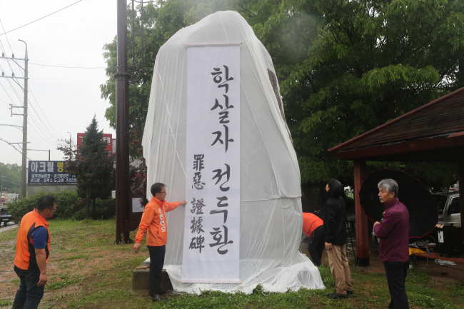 5·18 광주민주화운동 기념일을 하루 앞둔 17일 경기도 포천시 소흘읍 국도 43호선 축석고개에서 포천진보시민네트워크가 호국로 기념비 철거를 요구하는 퍼포먼스를 벌이고 있다. 호국로라 불리는 국도 43호선은 1987년 완공됐으며 기념비에는 전두환 전 대통령 친필 글씨로 호국로(護國路)가 한자로 새겨져 있다.(사진=연합뉴스)
