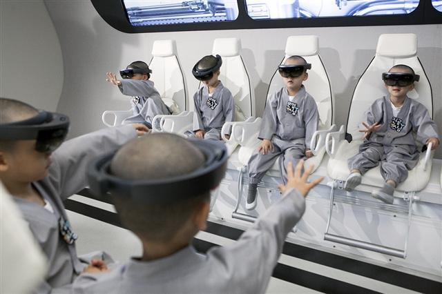 21일 SK텔레콤의 ICT 체험관 ‘티움(T.um)‘을 방문한 조계종의 동자승들이 증강현실 등을 체험하고 있다. [제공=SK텔레콤]