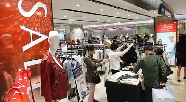 Customers look at clothes at a department store in April 2018, in this file photo. (Yonhap)