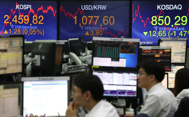 Currency traders work in front of electronic signs in the trading room of KEB-Hana Bank's headquarters in Seoul on May 16, 2018. (Yonhap)