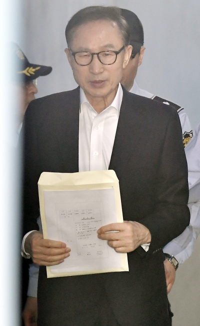 110억원대 뇌물수수와 350억원대 다스 횡령 등 혐의로 구속기소 된 이명박 전 대통령이 23일 오후 서울 서초구 서울중앙지방법원에서 열린 첫 공판에 출석하기 위해 호송차에서 내려 법정으로 향하고 있다. [사진=연합뉴스]