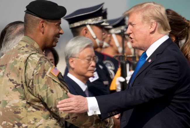 US President Donald Trump, right, is greeted by US Forces Korea Commander General Vincent Brooks, left, as he arrives at Osan Air Base in Pyeongtaek, South Korea on November 7, 2017.(AP)