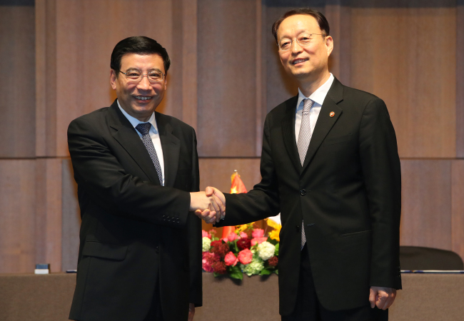 South Korean Trade, Industry and Energy Minister Paik Un-gyu (R) shakes hands with Chinese Industry and Information Technology Minister Miao Wei prior to their talks at a Seoul hotel on May 24. (Yonhap)