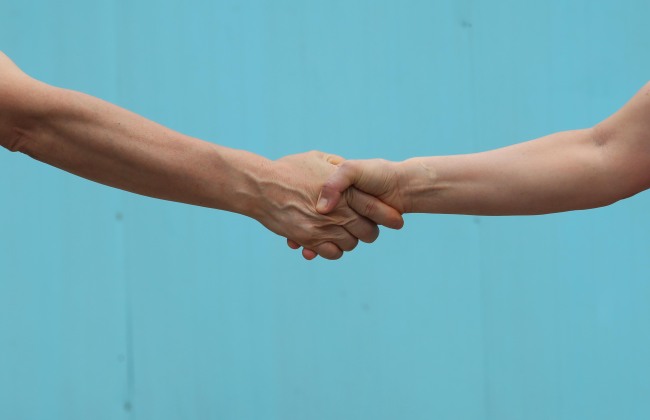 Visitors shake hands at a replica set of Panmunjeom. (Yonhap)